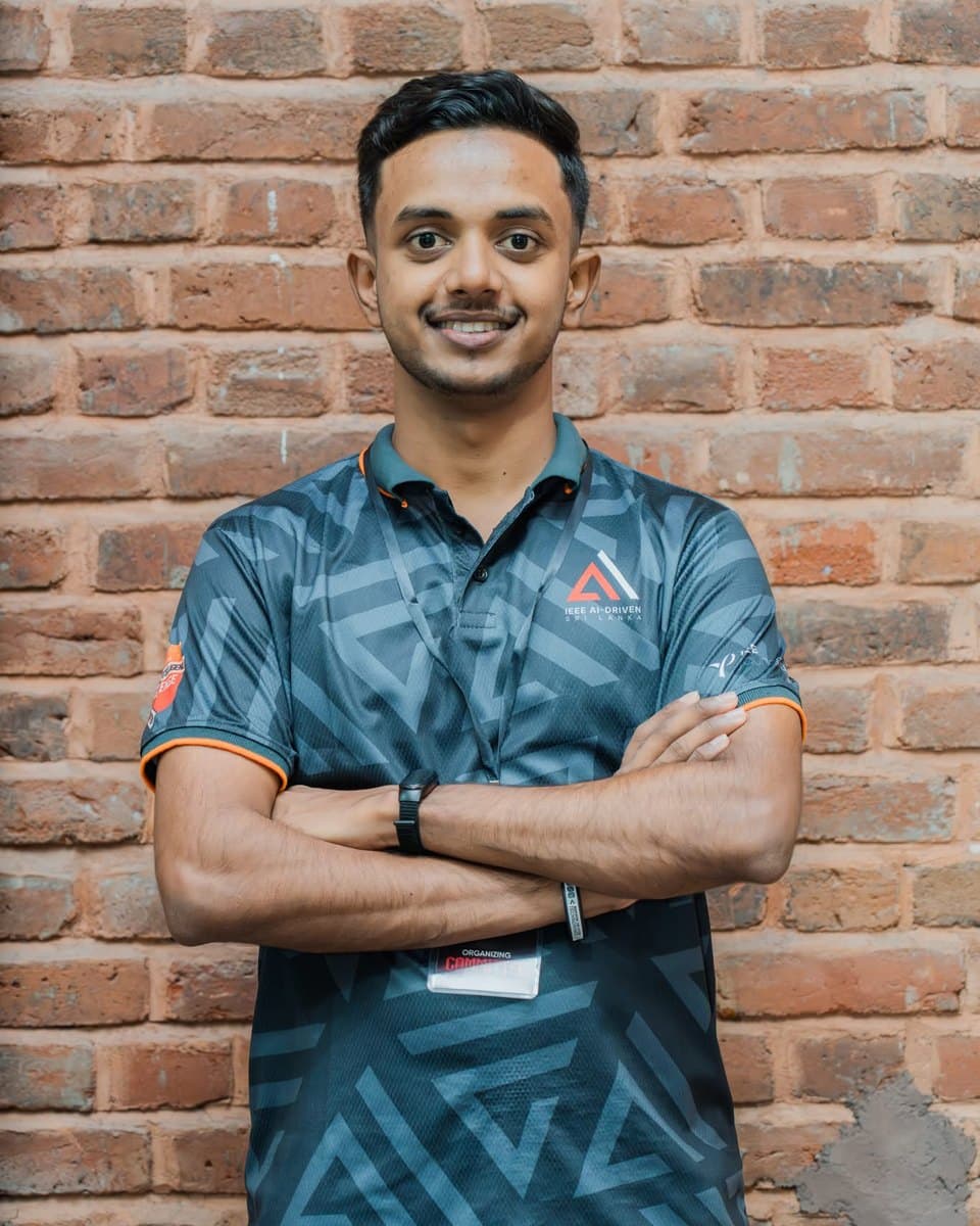 Tehan smiling with arms crossed, wearing an AI-Driven event badge